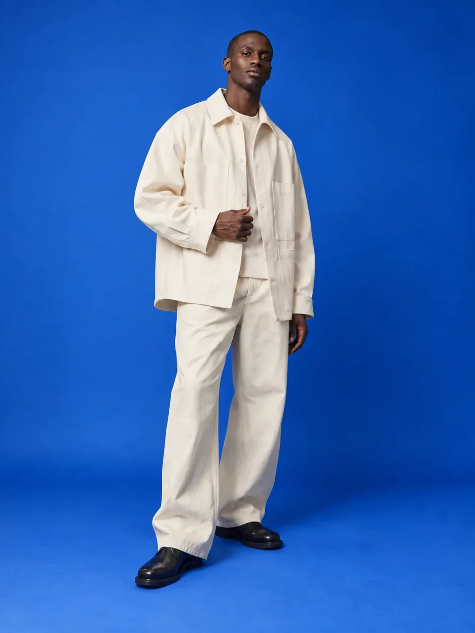 Immagine moda con un modello in completo avorio su fondo blu